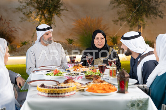 تجمع العائلة على افطار شهر رمضان المبارك, عائلة عربية خليجية اماراتية مجتمعة على طاولة الطعام المليئة بأشهى المأكولات, الاحتفال بالمناسبات و الاعياد الاسلامية, أجواء أسرية مليئة بالحب, ايماءات السعادة بقدوم شهر الخير