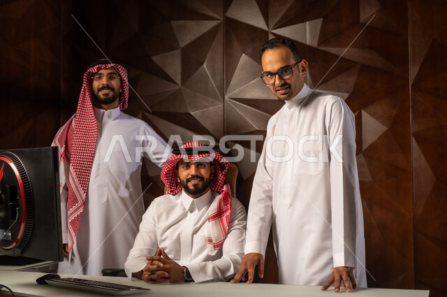 النظر الى الكاميرا بتعابير وايماءات السرور والسعادة, مهنة ووظيفة ادارية سعودية, شرح خطط و استراتيجيات المهام المطلوبة, التعارف وبناء العلاقات الاجتماعية, مجموعة رجال عرب خليجيين سعوديين يرتدون الزي التقليدي في مقر الشركة