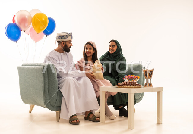 Rituals of celebrations and happy occasions in the Sultanate of Oman, an atmosphere of joy, happiness and decorations, distributing traditional sweets during holidays, a portrait of an Arab Gulf Omani family celebrating the blessed Eid, wearing traditional Omani costumes, the concept of generosity and offering Arab hospitality, white background.