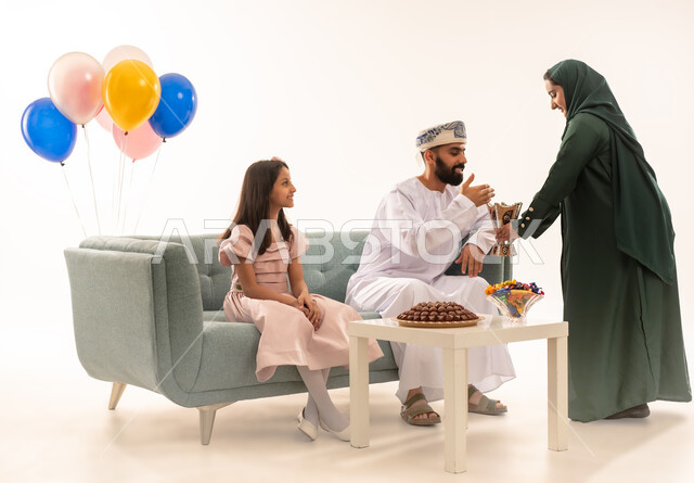 Celebration rituals on Eid morning, family gatherings and sitting happily together, an Omani Arab man burning incense and using luxurious oud perfumes to welcome the blessed Eid, portrait of an Omani Gulf Arab family celebrating Islamic occasions, white background.