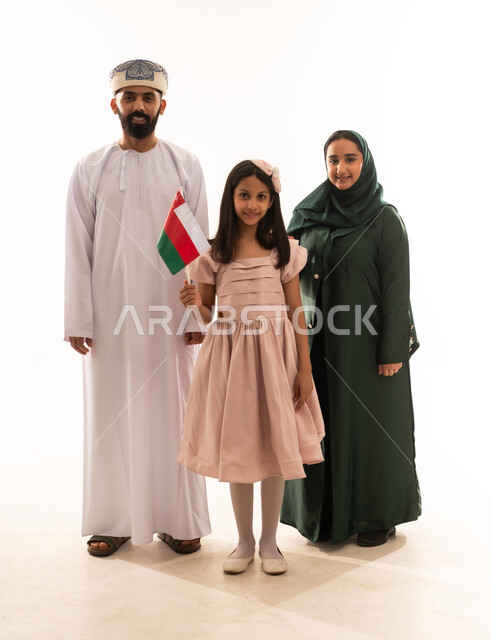 Pride in Omani symbols and flag, national holidays and occasions, commemorating Omani National Day, portrait of an Omani Gulf Arab family wearing traditional Omani clothing, an Omani girl holding a small flag of the Sultanate of Oman, the concept of love and belonging to the homeland, full body, white background.