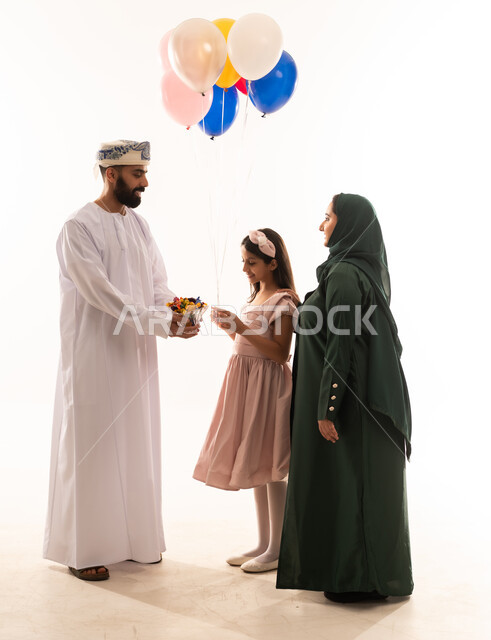 كرم الضيافة وحسن الاستقبال ، المعايدات والتهنئات وطقوس المناسبات الاسلامية في سلطنة عمان، ارتداء الأزياء العمانية التقليدية، توزيع الحلويات الشعبية في الأعياد، جو البهجة والفرح والزينة، بورتريه لعائلة عربية خليجية عمانية تحتفل بالعيد المبارك، خلفية بيضاء .