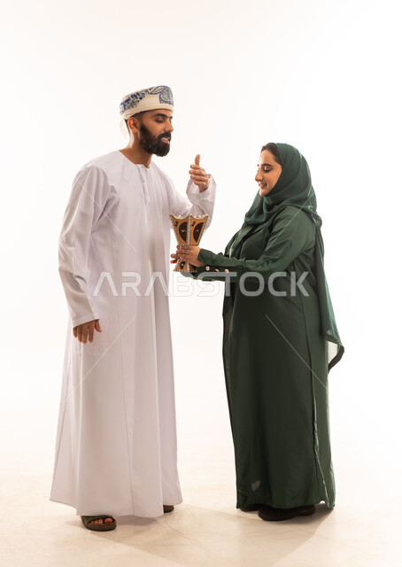 التطيب والتعطر, الاستعداد للخروج ، بورتريه لشابة عربية خليجية عمانية تحمل حامل البخور( المبخرة ) ، رجل عربي خليجي عماني يرتدي الدشداشة والكمة ، استخدام خشب العود في المناسبات الاجتماعية و الدينية ، خلفية بيضاء .