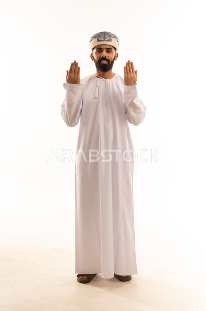 طلب التوقف وعدم الاقتراب, مفهوم الرفض والامتناع والانزعاج, بورتريه لرجل عربي خليجي عماني يرتدي الدشداشة والكمه يمد يده نحو الأمام مع رفع كفيه بإيماءات النهي عن فعل امر ما, تعابير الحزم والجدية, صورة الجسم بالطول الكامل, خلفية بيضاء .
