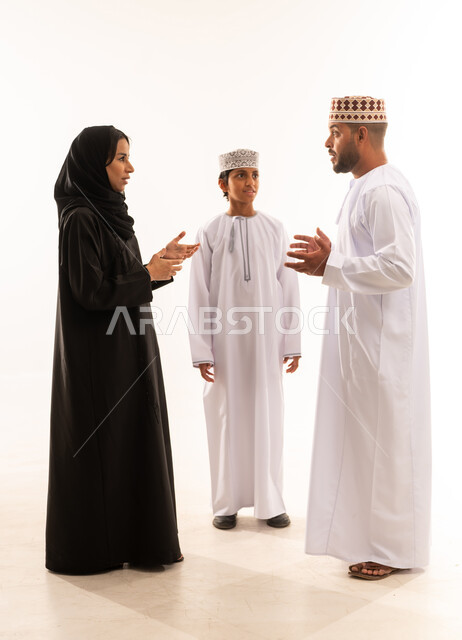 مفهوم تبادل الأحاديث والدردشات مع الأهل، مشاعر الألفه والمحبه بين أفراد العائله، بورتريه لعائلة عربية خليجية عمانية ترتدي الملابس العمانية التقليدية تقوم بالنقاش حول موضوع معين، ايماءات الجديه في الحوار، الجسم بالطول الكامل، خلفية بيضاء .