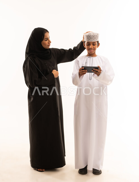 أجواء عائليه منزليه هادئه ، قضاء أوقات مليئه بالحب والموده، عائله عربيه خليجيه عمانية  تقوم بمشاهدة المسلسلات الممتعه عبر جهاز الجوال ، متابعه مواقع التواصل الاجتماعي، استخدام الأجهزة الالكترونيه والتقنيات الحديثه، خلفية بيضاء.