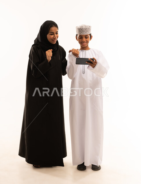 قضاء أوقات مليئه بالحب والموده، أجواء عائليه منزليه هادئه ، عائله عربيه خليجيه عمانية  تقوم بمشاهدة المسلسلات الممتعه عبر جهاز الجوال ، متابعه مواقع التواصل الاجتماعي، استخدام الأجهزة الالكترونيه والتقنيات الحديثه، خلفية بيضاء.