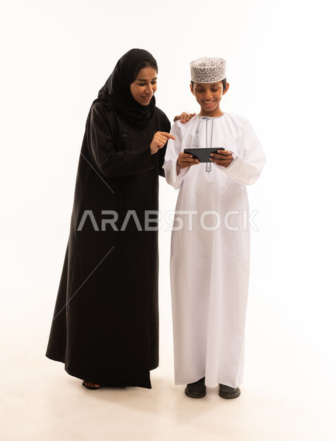 قضاء أوقات مليئه بالحب والموده، عائله عربيه خليجيه عمانية  تقوم بمشاهدة المسلسلات الممتعه عبر جهاز الجوال ، متابعه مواقع التواصل الاجتماعي، استخدام الأجهزة الالكترونيه والتقنيات الحديثه، أجواء عائليه منزليه هادئه ، خلفية بيضاء.