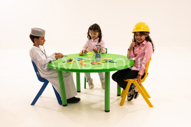 Introducing children to the concept of engineering and future careers, integrating education with play in kindergarten, portrait of Gulf Arab Omani students performing role-playing activities about work, gestures of pleasure and happiness, engineering profession and job, white background