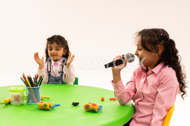 موهبة الغناء والتدريب الصوتي، إيماءات الإندماج والتفاعل مع الموسيقا،  بورتريه لاولاد عرب خليجيين سعوديين يرتدون الزي الكاجوال يستمتعون بالغناء والتصفيق، تقديم العروض الفنيه المسرحيه الغنائيه، تسجيل مقطع صوتي غنائي، تنمية مواهب الأطفال في الروضة، خلفيه بيضاء