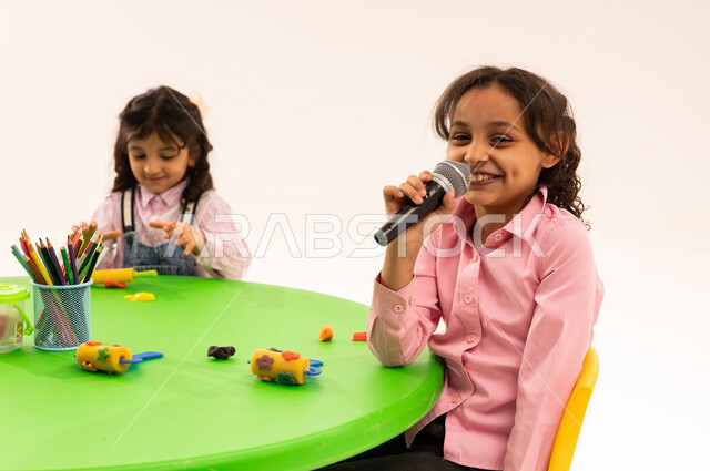 Singing talent and vocal training, gestures of integration and interaction with music, portrait of Saudi Arabian Gulf boys in casual clothes enjoying singing and clapping, presenting musical theatrical performances, recording a singing audio clip, developing children's talents in kindergarten, white background