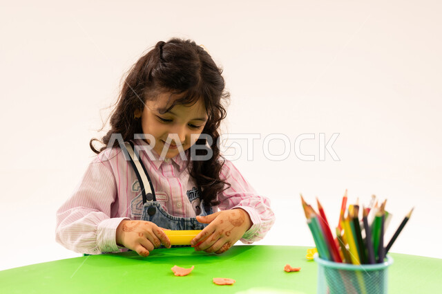 القيام بالمهارات و الأنشطة المسلية الممتعة، تنيمة المهارات الفنية بالتشكيل، الجلسات والحصص التعليمية في الروضات السعودية، بورتريه لطلاب عرب خليجيين سعوديين يقومون باللعب في الصلصال والمعجون الملون، تنمية القدرات العقلية والذهنية، خلفية بيضاء