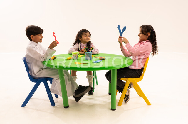 تعلم الأرقام والأعداد العربية وأشكالها،  بوتريه لاولاد عرب خليجيين سعوديين يرتدون الزي الكاجوال يتعلمون الحساب، نشاطات ترفيهية وتعليمية تساعد على تنمية القدرات الفكرية، التعاون والمشاركة بين اولاد الروضة في تعلم الرياضيات، خلفية بيضاء
