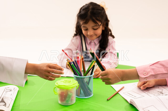 المشاركة وتبادل الاقلام، تقوية المهارات الفنية بالرسم والتلوين، الجلسات والحصص التعليمية في الروضات السعودية، بورتريه لطلاب عرب خليجيين سعوديين يقومون بتلوين الرسومات بايماءات السرور، القيام بالمهارات والأنشطة المختلفة لتنمية القدرات العقلية والذهنية، خلفية بيضاء