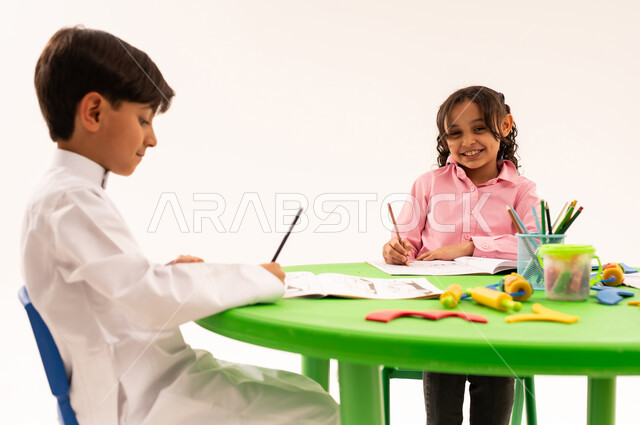 تعزيز المهارات الفنية بالرسم والتلوين، الجلسات والحصص التعليمية في الروضات السعودية، بورتريه لطلاب عرب خليجيين سعوديين يقومون بتلوين الرسومات بايماءات الاندماج، القيام بالمهارات و الأنشطة المختلفة لتنمية القدرات العقلية والذهنية، خلفية بيضاء