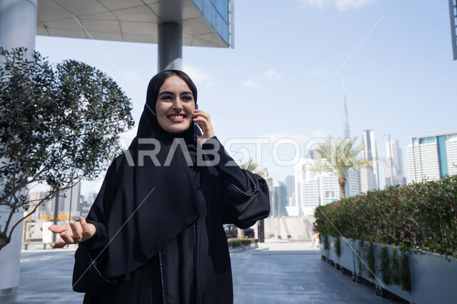 حركات ايدي بتعابير التساؤل ، ايماءات السعادة لسماع الاخبار المبهجة ، برامج وتطبيقات الجوال المتنوعة ، الاطمئنان على الأصدقاء، تبادل الاحاديث والاخبار بين العائلة، امرأة اماراتية تقوم بإستخدام الأجهزة التقنية الحديثة، شابة عربية خليجية سعودية مبتسمة تمسك بيدها جهاز الهاتف المحمول تقوم بإجراء مكالمة هاتفية  .