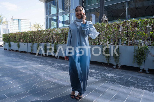 إجراء مكالمه هاتفيه عبر الهاتف المحمول، إمرأة عربية خليجية اماراتية تقضي أوقات ممتعة في إحدى الحدائق في الامارات، دردشه ومحادثات, نزهه في الهواء الطلق، سيدة سعودية تقوم بجولة في الطبيعة , صورة الجسم بالطول الكامل.