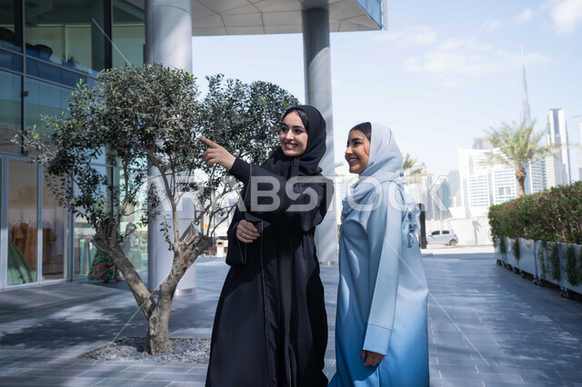 الاشاره تجاه هدف ما بسعادة ، صديقتان عربيتان خليجيتان سعوديتان محجبتان ترتديان العباءات والحجاب، قضاء أوقات ممتعة في الطبيعة ، زميلتان اماراتيان تنظران الى شئ ما بتعابير السرور ، تقوية وتعزيز العلاقات الاجتماعية ، مفهوم الأناقة والاهتمام بالمظهر الخارجي ، استنشاق الهواء النقي في وقت النهار .
