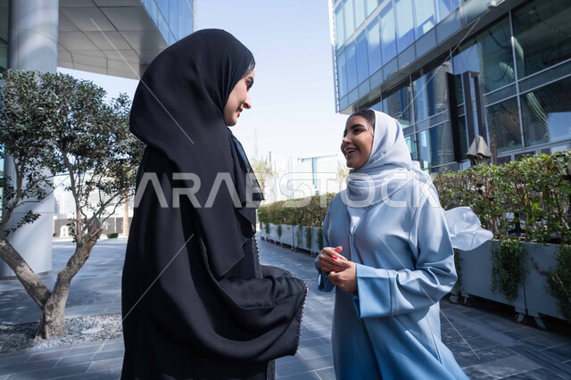 الود بين الاصدقاء ، زميلتان اماراتيان تنظران الى بعضهما بتعابير السرور ، تقوية وتعزيز العلاقات الاجتماعية ، مفهوم الأناقة والاهتمام بالمظهر الخارجي ، صديقتان عربيتان خليجيتان سعوديتان محجبتان ترتديان العباءات والحجاب، قضاء أوقات ممتعة في الطبيعة ، الاستمتاع والتجول واستنشاق الهواء النقي في وقت النهار .