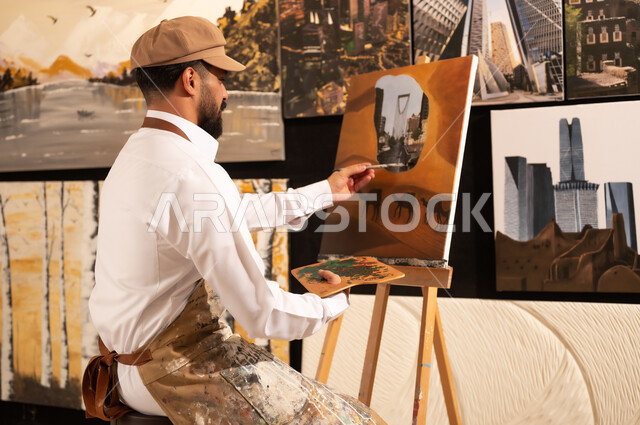 ممارسة هواية الفنون اليدوية, الشغف برسم الحيوانات, رسام عربي خليجي سعودي يرتدي الثوب التقليدي ومريلة الرسم  يقوم برسم جمال في الصحراء ومعالم مدينة الرياض, معرض الرسومات و اللوحات التشكيلية في العاصمة السعودية, مفهوم الموهبة و الإبداع