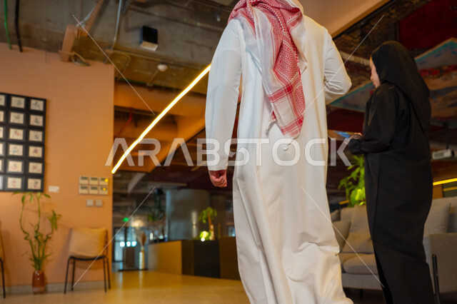 الوحده والعمل الجماعي، تحقيق اهداف الشركة، تطوير العمل وحل المشكلات، مهن ووظائف سعودية مكتبية، تبادل الاراء والخبرات، اجتماع رجل وسيدة اعمال عربيان سعوديان خليجيان يتجولان في مقر الشركة، ادارة العمل باستخدام التابليت، مناقشة وتوزيع مهام العمل، بيئة العمل السعودي