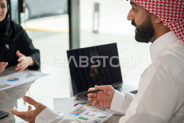شرح و تحليل الرسوم البيانية, دمج الأجهزة التقنية الحديثة بالأعمال المكتبية، دراسة أوراق البيانات الإحصائية, تطوير المشاريع و الاستثمارات, إدارة و تقسيم المهام، فريق عمل عربي خليجي سعودي يقوم بإجراء اجتماع عمل داخل غرفة الاجتماعات في مقر الشركة