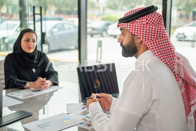 شرح و تحليل الرسوم البيانية, دمج الأجهزة التقنية الحديثة بالأعمال المكتبية، دراسة أوراق البيانات الإحصائية, تطوير المشاريع و الاستثمارات, إدارة و تقسيم المهام، فريق عمل عربي خليجي سعودي يقوم بإجراء اجتماع عمل داخل غرفة الاجتماعات في مقر الشركة