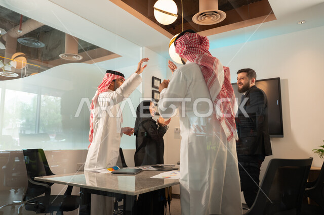 دمج الأجهزة التقنية الحديثة بالأعمال المكتبية، دراسة أوراق البيانات الإحصائية, تطوير المشاريع و الاستثمارات, إدارة و تقسيم المهام، فريق عمل عربي خليجي سعودي يقوم بإجراء اجتماع عمل داخل غرفة الاجتماعات في مقر الشركة، شرح و تحليل الرسوم البيانية