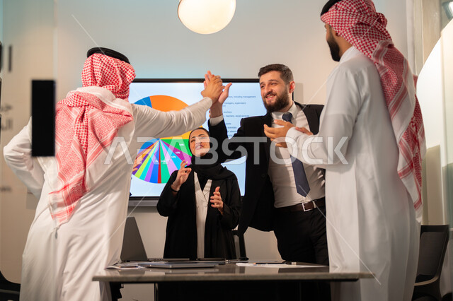 دمج الأجهزة التقنية الحديثة بالأعمال المكتبية، دراسة أوراق البيانات الإحصائية, تطوير المشاريع و الاستثمارات, إدارة و تقسيم المهام، فريق عمل عربي خليجي سعودي يقوم بإجراء اجتماع عمل داخل غرفة الاجتماعات في مقر الشركة، شرح و تحليل الرسوم البيانية