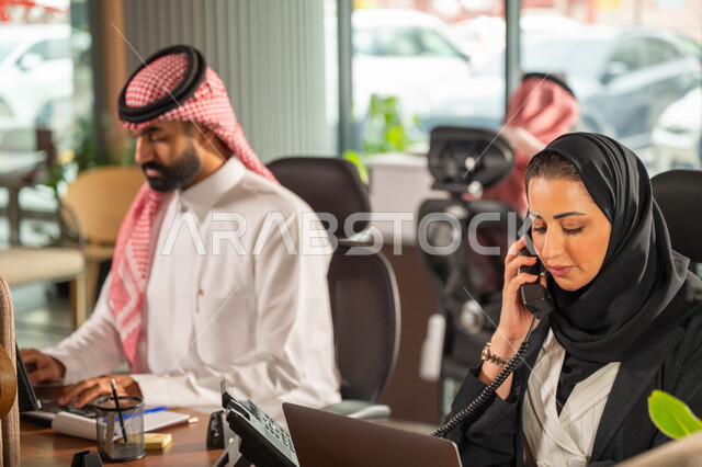 مفهوم الاستعلامات والاستفسارات، موظفة عربية خليجية سعودية محجبة مبتسمة تعمل في خدمة العملاء تقوم بالرد على الهاتف، الاجابه والرد على الأسئلة، العمل وادخال البيانات على الحاسوب، متابعة وتطوير العمل