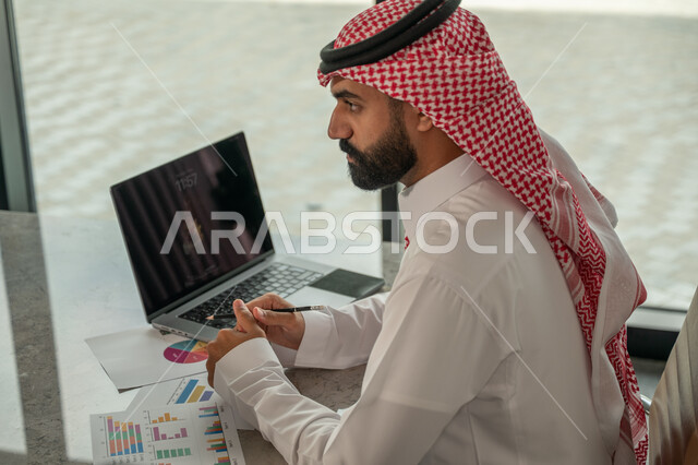  مهنة ووظيفة سعودية مكتبية، تطوير العمل وحل المشكلات، صورة مقربة لرجل عربي خليجي سعودي يعمل داخل مقر الشركة، تطوير ودراسة وتحليل المشاريع الجديدة، تحليل النتائج والرسوم البيانية، استخدام جهاز تقني حديث