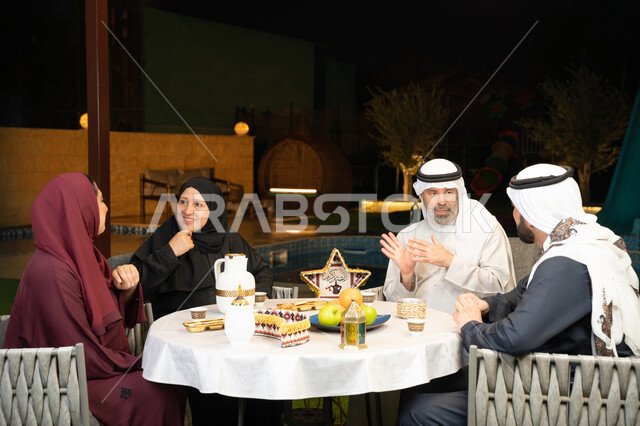 كرم الضيافة وحسن الاستقبال في شهر رمضان المبارك، تبادل الأحاديث بين أفراد الأسرة، أجواء عائلية دينية رمضانية سعيدة، ديكور وزينة المناسبات الإسلامية، عائلة عربية خليجية اماراتية مجتمعة في جلسة ليلية خارجية في احدى الشاليهات
