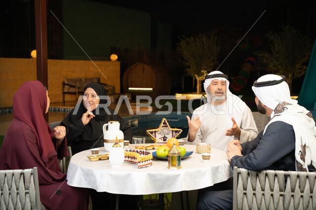 أجواء عائلية دينية رمضانية سعيدة، ديكور وزينة المناسبات الإسلامية، التسامر وتبادل الأحاديث بين أفراد الأسرة، أداء فريضة الصيام في شهر رمضان المبارك، عائلة عربية خليجية اماراتية مجتمعة في احدى الشاليهات الراقية