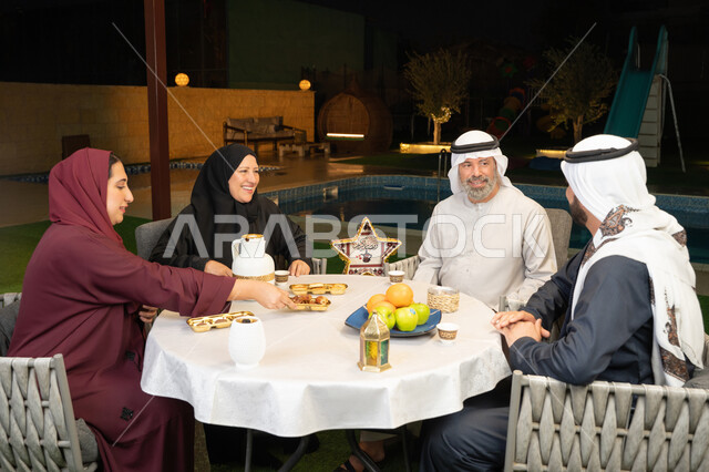 التسامر وتبادل الأحاديث بين أفراد الأسرة، أجواء عائلية دينية رمضانية سعيدة، ديكور وزينة المناسبات الإسلامية، أداء فريضة الصيام في شهر رمضان المبارك، عائلة عربية خليجية اماراتية مجتمعة في احدى الشاليهات الراقية