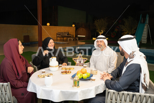 التسامر وتبادل الأحاديث بين أفراد الأسرة، أجواء عائلية دينية رمضانية سعيدة، ديكور وزينة المناسبات الإسلامية، أداء فريضة الصيام في شهر رمضان المبارك، عائلة عربية خليجية اماراتية مجتمعة في احدى الشاليهات الراقية