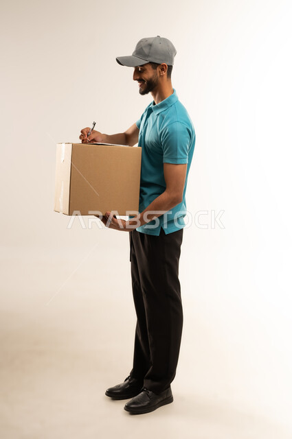 Express deliveries, delivering goods and orders to customers, smiling Omani Gulf Arab worker wearing casual clothes holding a cardboard box and parcel delivery papers, Saudi man checking the order with expressions of pleasure and satisfaction, full body, white background