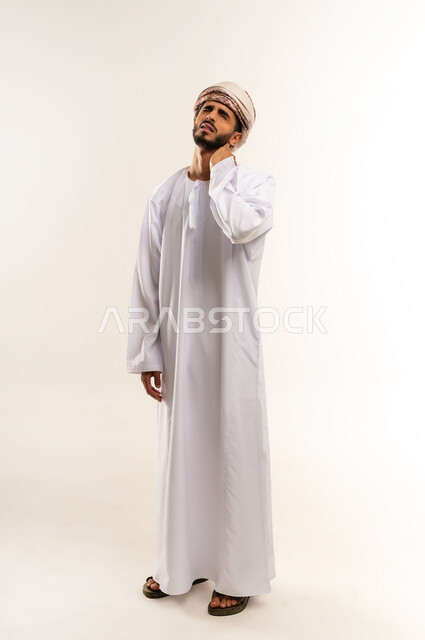 آلام العنق والعمود الفقري, وجع مفاصل و عظام الرقبة, الحاجة للعلاج الفيزيائي، الإحساس بالتعب والإرهاق, بورتريه لرجل عربي خليجي عماني يرتدي الدشداشة والعمامة يضع يده حول عنقه بإيماءات الألم, الجسم بالطول الكامل, خلفية بيضاء .