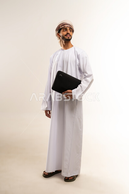الذهاب إلى دوام العمل بنشاط,  الشعور بالسرور لتحقيق أهداف الشركة, بورتريه لرجل عربي عماني خليجي مبتسم يرتدي الدشداشة والكمة ينظر جانباً بايماءات السعادة يحمل حقيبة يد سوداء , الاهتمام بالأناقة والمظهر الخارجي، صورة الجسم بالكامل, خلفية بيضاء .