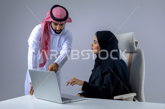  مناقشة وتوزيع مهام العمل، تطوير العمل وحل المشكلات، مهن ووظائف سعودية مكتبية، تبادل الاراء والخبرات، بورتريه لرجل وسيدة اعمال عربيان سعوديان خليجيان في مقر الشركة، ادارة العمل باستخدام الحاسب المحمول، الوحده والعمل الجماعي، تحقيق اهداف الشركة، خلفية بيضاء