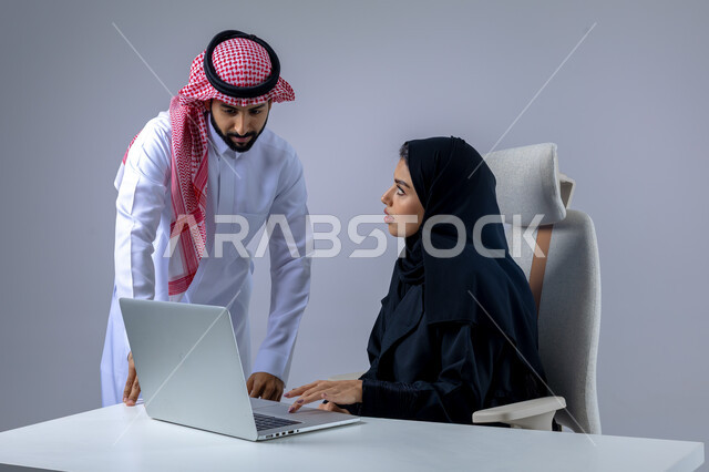  مناقشة وتوزيع مهام العمل، تطوير العمل وحل المشكلات، مهن ووظائف سعودية مكتبية، تبادل الاراء والخبرات، بورتريه لرجل وسيدة اعمال عربيان سعوديان خليجيان في مقر الشركة، ادارة العمل باستخدام الحاسب المحمول، الوحده والعمل الجماعي، تحقيق اهداف الشركة، خلفية بيضاء