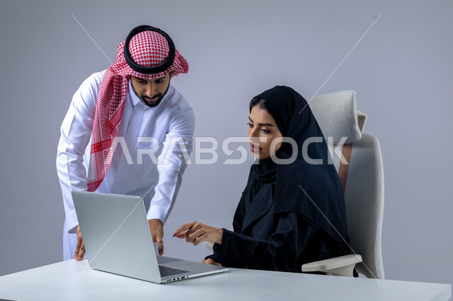  مناقشة وتوزيع مهام العمل، تطوير العمل وحل المشكلات، مهن ووظائف سعودية مكتبية، تبادل الاراء والخبرات، بورتريه لرجل وسيدة اعمال عربيان سعوديان خليجيان في مقر الشركة، ادارة العمل باستخدام الحاسب المحمول، الوحده والعمل الجماعي، تحقيق اهداف الشركة، خلفية بيضاء