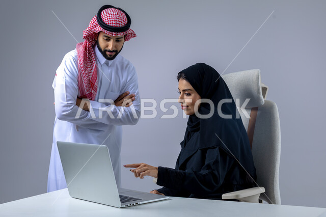  مناقشة وتوزيع مهام العمل، تطوير العمل وحل المشكلات، مهن ووظائف سعودية مكتبية، تبادل الاراء والخبرات، بورتريه لرجل وسيدة اعمال عربيان سعوديان خليجيان في مقر الشركة، ادارة العمل باستخدام الحاسب المحمول، الوحده والعمل الجماعي، تحقيق اهداف الشركة، خلفية بيضاء