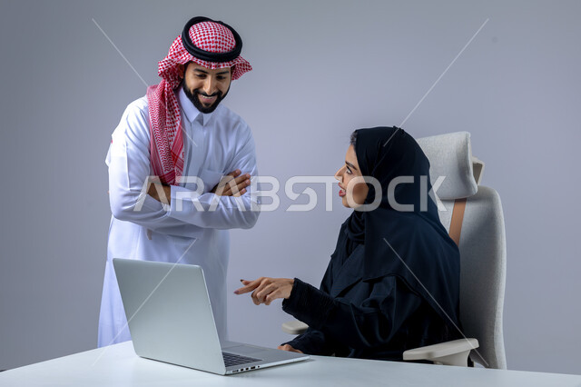  مناقشة وتوزيع مهام العمل، تطوير العمل وحل المشكلات، مهن ووظائف سعودية مكتبية، تبادل الاراء والخبرات، بورتريه لرجل وسيدة اعمال عربيان سعوديان خليجيان في مقر الشركة، ادارة العمل باستخدام الحاسب المحمول، الوحده والعمل الجماعي، تحقيق اهداف الشركة، خلفية بيضاء