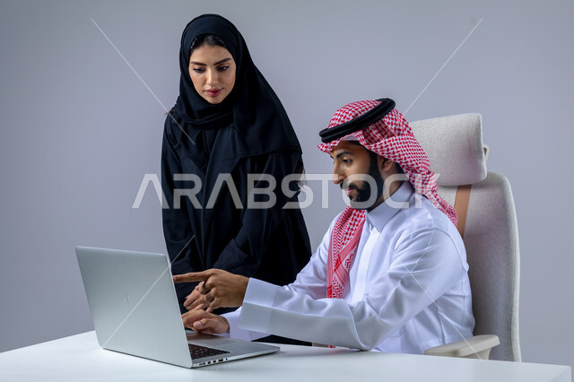  مناقشة وتوزيع مهام العمل، تطوير العمل وحل المشكلات، مهن ووظائف سعودية مكتبية، تبادل الاراء والخبرات، بورتريه لرجل وسيدة اعمال عربيان سعوديان خليجيان في مقر الشركة، ادارة العمل باستخدام الحاسب المحمول، الوحده والعمل الجماعي، تحقيق اهداف الشركة، خلفية بيضاء
