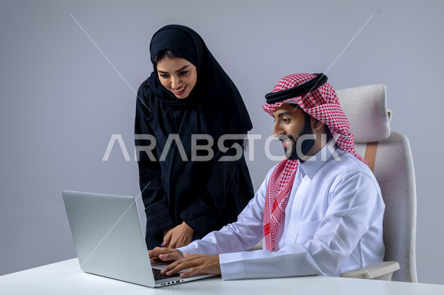  مناقشة وتوزيع مهام العمل، تطوير العمل وحل المشكلات، مهن ووظائف سعودية مكتبية، تبادل الاراء والخبرات، بورتريه لرجل وسيدة اعمال عربيان سعوديان خليجيان في مقر الشركة، ادارة العمل باستخدام الحاسب المحمول، الوحده والعمل الجماعي، تحقيق اهداف الشركة، خلفية بيضاء