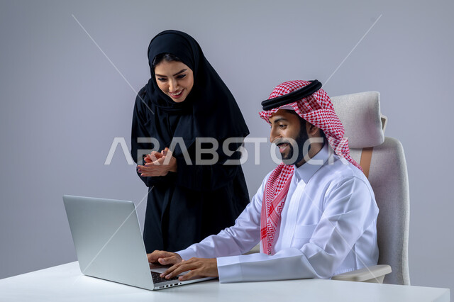  مناقشة وتوزيع مهام العمل، تطوير العمل وحل المشكلات، مهن ووظائف سعودية مكتبية، تبادل الاراء والخبرات، بورتريه لرجل وسيدة اعمال عربيان سعوديان خليجيان في مقر الشركة، ادارة العمل باستخدام الحاسب المحمول، الوحده والعمل الجماعي، تحقيق اهداف الشركة، خلفية بيضاء