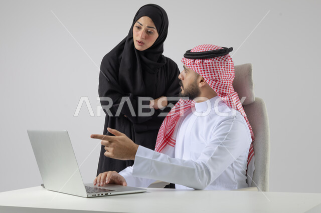 تبادل الاراء والخبرات، بورتريه لرجل وسيدة اعمال عربيان سعوديان خليجيان في مقر الشركة، ادارة العمل باستخدام الحاسب المحمول، الوحده والعمل الجماعي، تحقيق اهداف الشركة، مناقشة وتوزيع مهام العمل، تطوير العمل وحل المشكلات، مهن ووظائف سعودية مكتبية، خلفية بيضاء