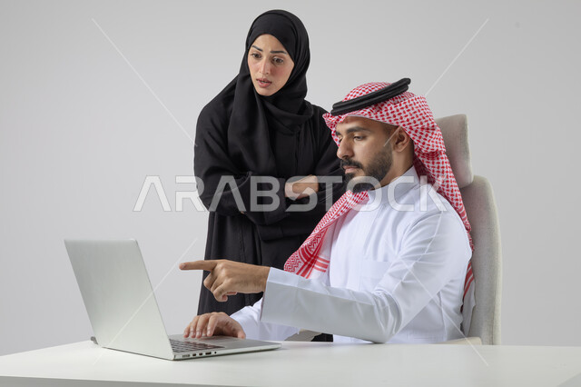تبادل الاراء والخبرات، بورتريه لرجل وسيدة اعمال عربيان سعوديان خليجيان في مقر الشركة، ادارة العمل باستخدام الحاسب المحمول، الوحده والعمل الجماعي، تحقيق اهداف الشركة، مناقشة وتوزيع مهام العمل، تطوير العمل وحل المشكلات، مهن ووظائف سعودية مكتبية، خلفية بيضاء