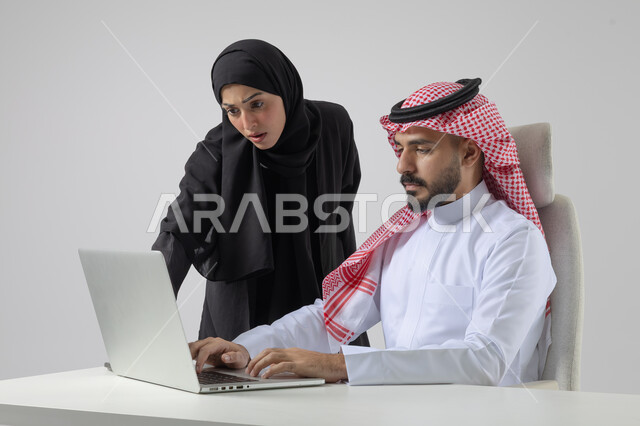 تبادل الاراء والخبرات، بورتريه لرجل وسيدة اعمال عربيان سعوديان خليجيان في مقر الشركة، ادارة العمل باستخدام الحاسب المحمول، الوحده والعمل الجماعي، تحقيق اهداف الشركة، مناقشة وتوزيع مهام العمل، تطوير العمل وحل المشكلات، مهن ووظائف سعودية مكتبية، خلفية بيضاء