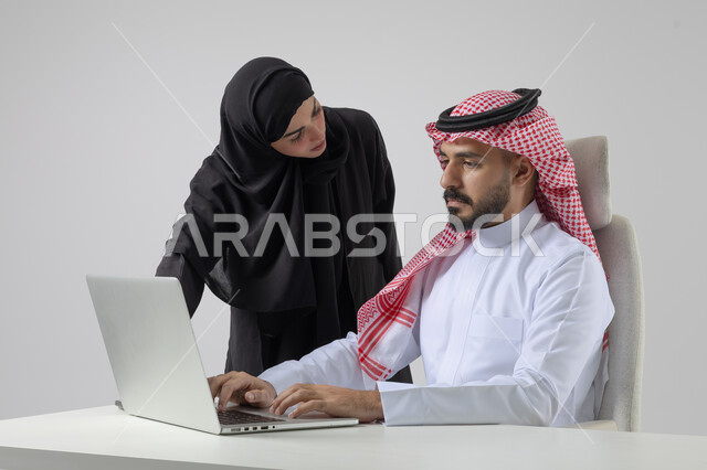  الوحده والعمل الجماعي، تبادل الاراء والخبرات، بورتريه لرجل وسيدة اعمال عربيان سعوديان خليجيان في مقر الشركة، ادارة العمل باستخدام الحاسب المحمول، تحقيق اهداف الشركة، مناقشة وتوزيع مهام العمل، تطوير العمل وحل المشكلات، مهن ووظائف سعودية مكتبية، خلفية بيضاء
